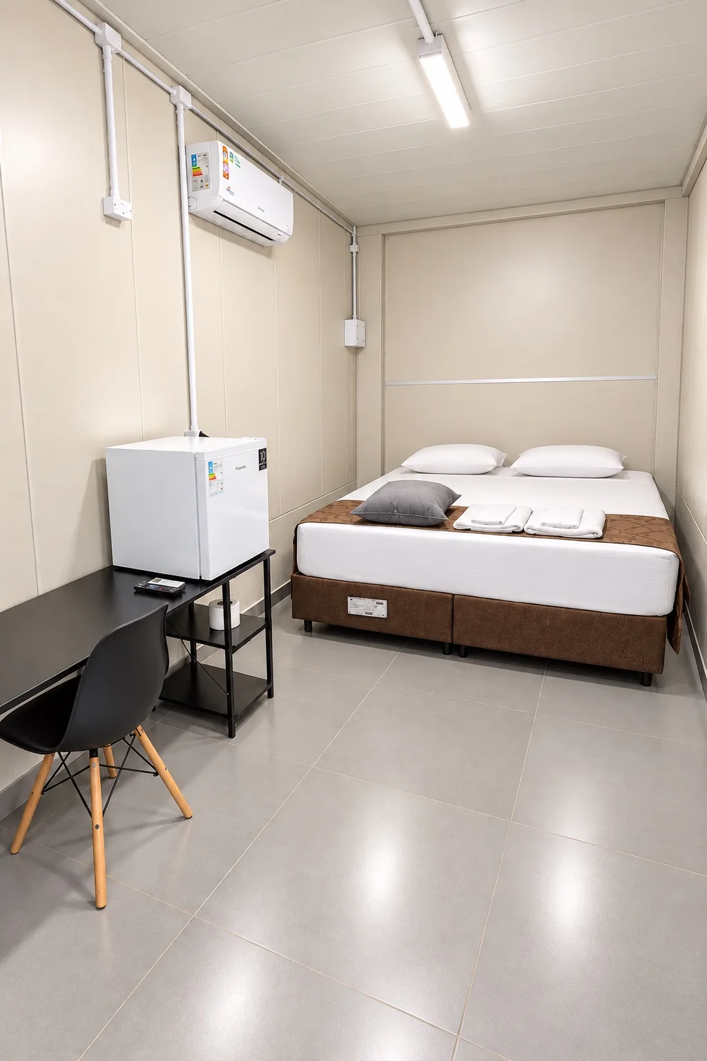 Quarto da Sleep Box com cama de casal, mesa, frigobar e ar-condicionado